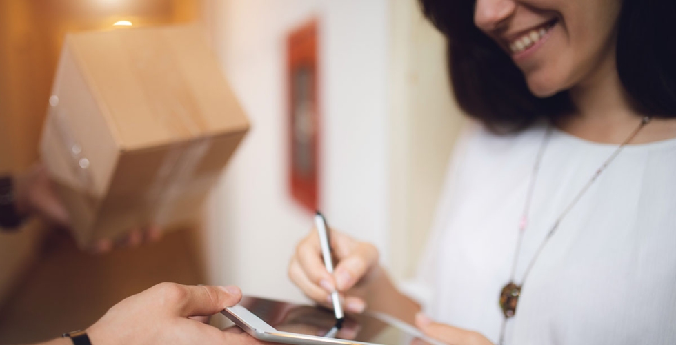 Lady signing for parcel delivery
